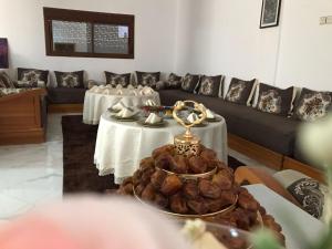 a living room with two tables and a couch at Maison d'hôte Riad Tounfite in Tounfit