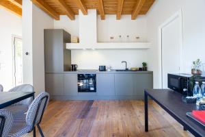 een woonkamer met een keuken met een tafel en stoelen bij Corte Barattina - Antica Dimora Tra Campagna e Città in Trebbo Di Reno