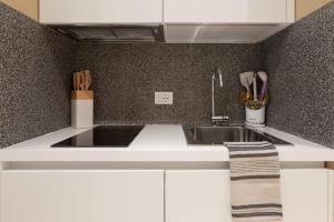 a kitchen with white cabinets and a sink at Chic Trieste Gem in Trieste +8 photos