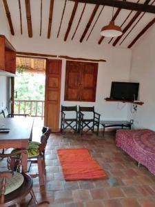salon z kanapą, stołem i telewizorem w obiekcie Casa en Barichara: la perfección hecha realidad! w mieście Barichara