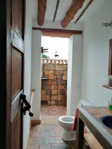 łazienka z toaletą, umywalką i drzwiami w obiekcie Casa en Barichara: la perfección hecha realidad! w mieście Barichara