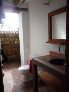 a bathroom with a toilet and a sink and a mirror at Casa en Barichara: la perfección hecha realidad! in Barichara