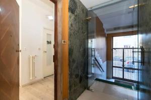 un couloir avec une porte en verre dans un bâtiment dans l'établissement city flat [strategic position], à Turin
