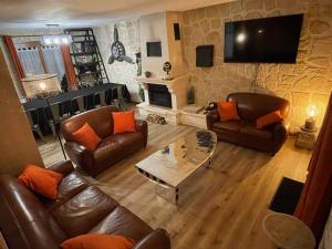 a living room with leather furniture and a tv at Le Panorama sur Beauval, face au Zoo de Beauval in Saint-Aignan