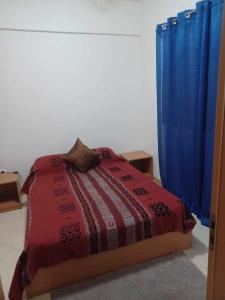 1 dormitorio con cama y cortina azul en Secularis Capital, en Praia