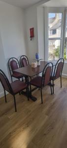 - une table à manger avec des chaises et du parquet dans l'établissement Comfy 2 bedroom Apt in central location, Newly Refurbished, à Plymouth