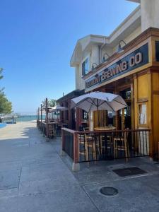 a restaurant with tables and umbrellas in front of a building at Island Vibes 1 bedroom in LongBeach-30 days min. in Long Beach