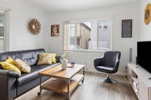 a living room with a couch and a table and a chair at Island Vibes 1 bedroom in LongBeach-30 days min. in Long Beach