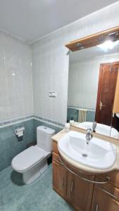 uma casa de banho com um lavatório, um WC e um espelho. em Apartamento ZONA em Albacete