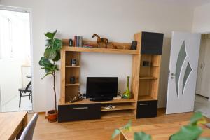 a living room with a tv on a wooden entertainment center at Magnolia in Burgas City