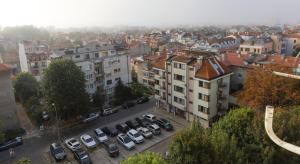 a city with cars parked in a parking lot at Magnolia in Burgas City