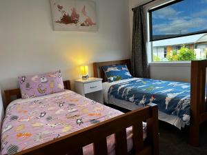 a bedroom with two beds and a window at LH Twizel Fountain Retreat in Twizel