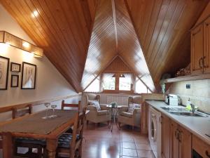 cocina con techo de madera y mesa en La Buhardilla de Gavin, en Gavín