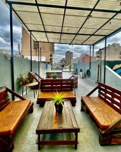 eine Terrasse mit Bänken und einem Tisch auf dem Dach in der Unterkunft Hostel Alvear in Cordoba