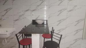 uma mesa com 4 cadeiras e um lavatório na casa de banho em 102 Apartamento em Aracruz ES em Aracruz