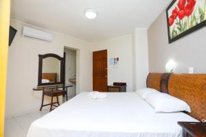 a bedroom with two white beds and a mirror at Hotel Parador in Cancún