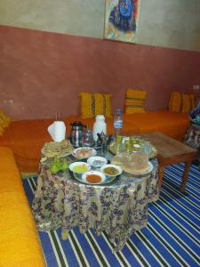 un tavolo con piatti di cibo sopra in un soggiorno di HÔTEL- KASBAH Aberdouz a Aït Hattab