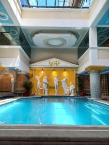 una piscina en un edificio con una pintura en la pared en Hotel Troya, en Ibarra