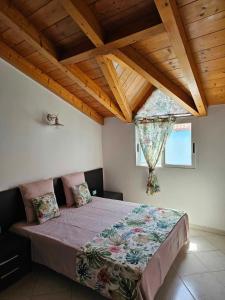 a bedroom with a bed in a room with wooden ceilings at Soleil Beach House in Santa Maria