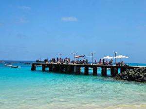 a group of people standing on a pier in the ocean at Soleil Beach House in Santa Maria