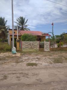 una casa con una puerta blanca delante de ella en Casa pé na areia ao lado de Mangue Seco, en Jandaíra