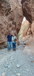 Due uomini sono in piedi in un canyon roccioso di HÔTEL- KASBAH Aberdouz a Aït Hattab