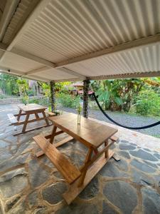 two picnic tables under a canopy on a stone patio at Casa de la playa in Santa Catalina