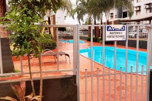 a gate with a sign next to a swimming pool at Confortável apt em Parauapebas in Parauapebas