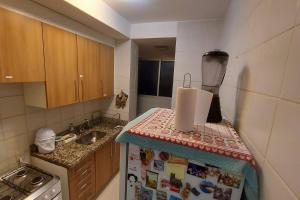 a small kitchen with a refrigerator and a sink at Confortável apt em Parauapebas in Parauapebas