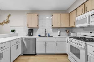 a white kitchen with white appliances and wooden cabinets at Downtown & Upscale in Buffalo