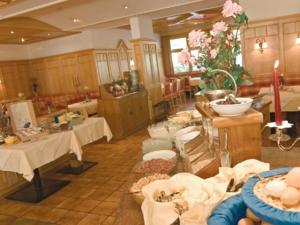 ein großes Zimmer mit zwei Tischen und Blumen darin in der Unterkunft Gasthof Pitztaler Hof in Wenns