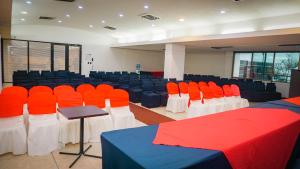 una sala de conferencias con mesas y sillas rojas y azules en Hotel Tonchalá, en Cúcuta