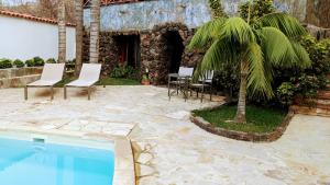 un patio con una mesa, sillas y una palmera en Las Villas de Gardel, en Icod de los Vinos