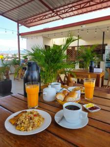 una mesa de madera cubierta con platos de comida y bebida en Residencial Brest Amazon Tarapoto en Tarapoto