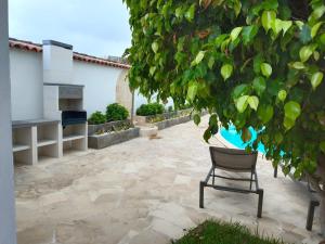 a chair sitting on a patio under a tree at Las Villas de Gardel in Icod de los Vinos