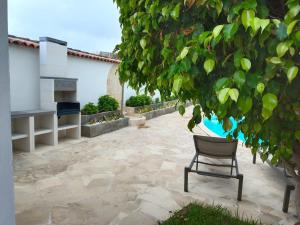 une chaise assise sur une terrasse sous un arbre dans l'établissement Las Villas de Gardel, à Icod de los Vinos