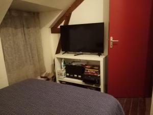 1 dormitorio con TV de pantalla plana y 1 cama en Chambre dans maison, en Betton