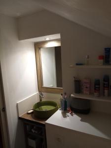 baño con lavabo verde y espejo en Chambre dans maison, en Betton