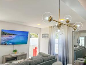 a living room with a couch and a chandelier at Luxury Villa with hot tub! Walk to Beach & Bars in Long Beach