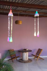 a room with a table and lights hanging from the ceiling at Calango Hostel in Ibicoara