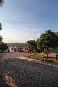 a cobblestone street with a house in the distance at Calango Hostel in Ibicoara