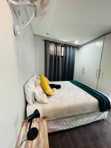 un dormitorio con una cama con un gato negro sobre ella en Wild olive A, en Windhoek