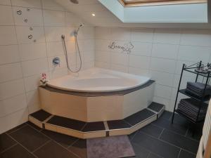 a bath tub with a shower in a bathroom at Lieblingsplatzl in Neustift im Stubaital