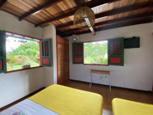 a bedroom with two beds and two windows at Casa Abba Hotel in La Tebaida
