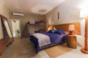 1 dormitorio con 1 cama con almohadas azules en Ka´ana Surf, en El Paredón Buena Vista
