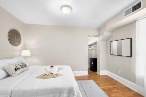 a white bedroom with a bed and a flat screen tv at 1 Bdrm Modern Posh Upenndrexel Univ in Philadelphia