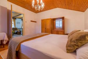 sypialnia z dużym białym łóżkiem z żyrandolem w obiekcie Apartment in Tribalj 41649 w mieście Tribalj