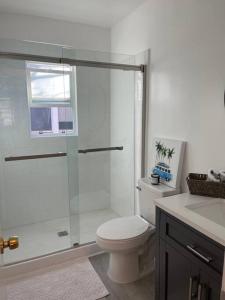 La salle de bains est pourvue de toilettes et d'une douche en verre. dans l'établissement Beautiful unit in the heart of Belmont Shores !, à Long Beach