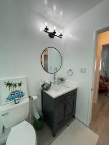 a bathroom with a toilet and a sink and a mirror at Beautiful unit in the heart of Belmont Shores ! in Long Beach