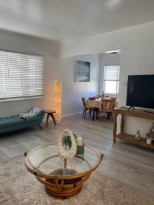a living room with a couch and a table at Beautiful unit in the heart of Belmont Shores ! in Long Beach